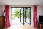 Three part bi fold door opening to the right and leading onto the patio